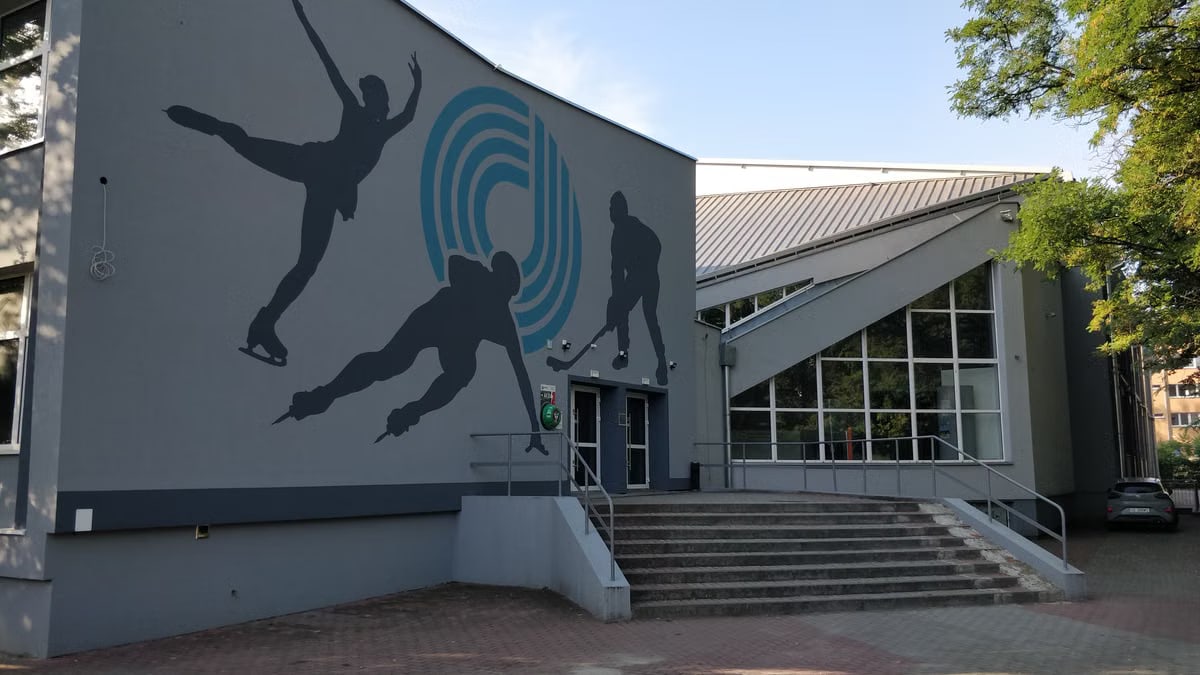 Contemporary ice rink entrance featuring a dynamic skating mural outside.